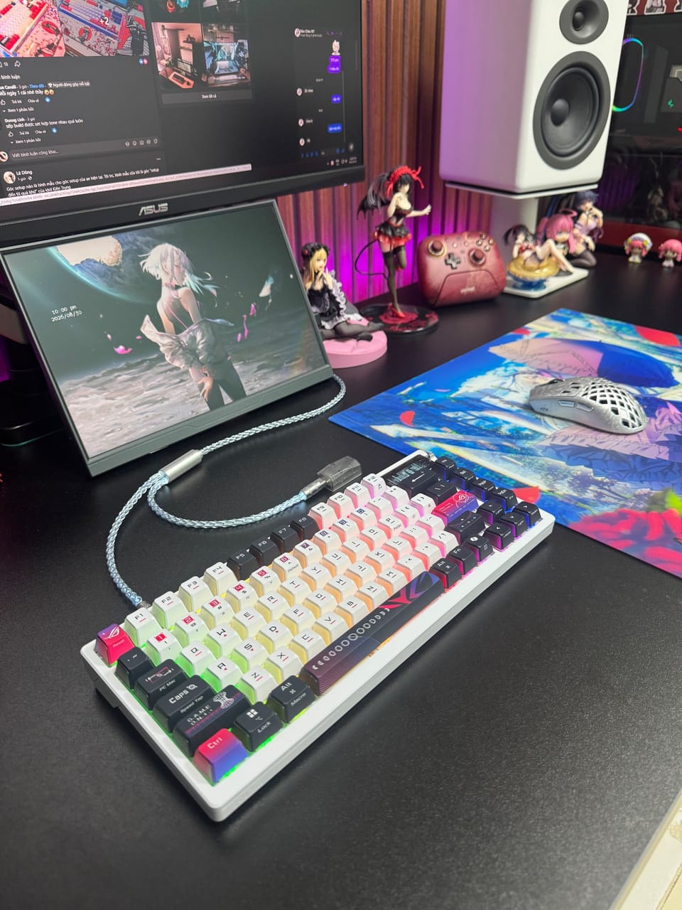 Góc máy của Wibu Hàng Hiệu: Góc bàn màu đen với bàn phím cơ trắng đen đèn RGB, chuột tổ ong, hai màn hình, loa trắng và nhiều mô hình anime.