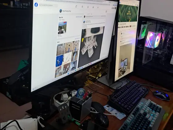 Góc máy của cuongknight: Bàn gỗ với hai màn hình, case kính có quạt RGB xanh lá, hai bàn phím cơ, chuột và nhiều đồ lặt vặt, dây điện bừa bộn.