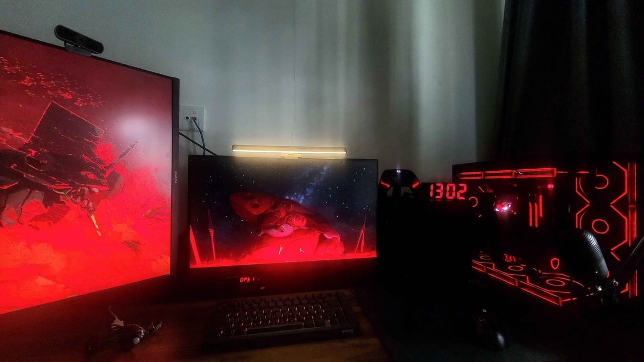 Setup góc máy của f0rsaken_: Góc máy tối với hai màn hình hình nền đỏ, đèn treo màn hình, bàn phím và case ánh đèn neon đỏ phong cách cyberpunk.