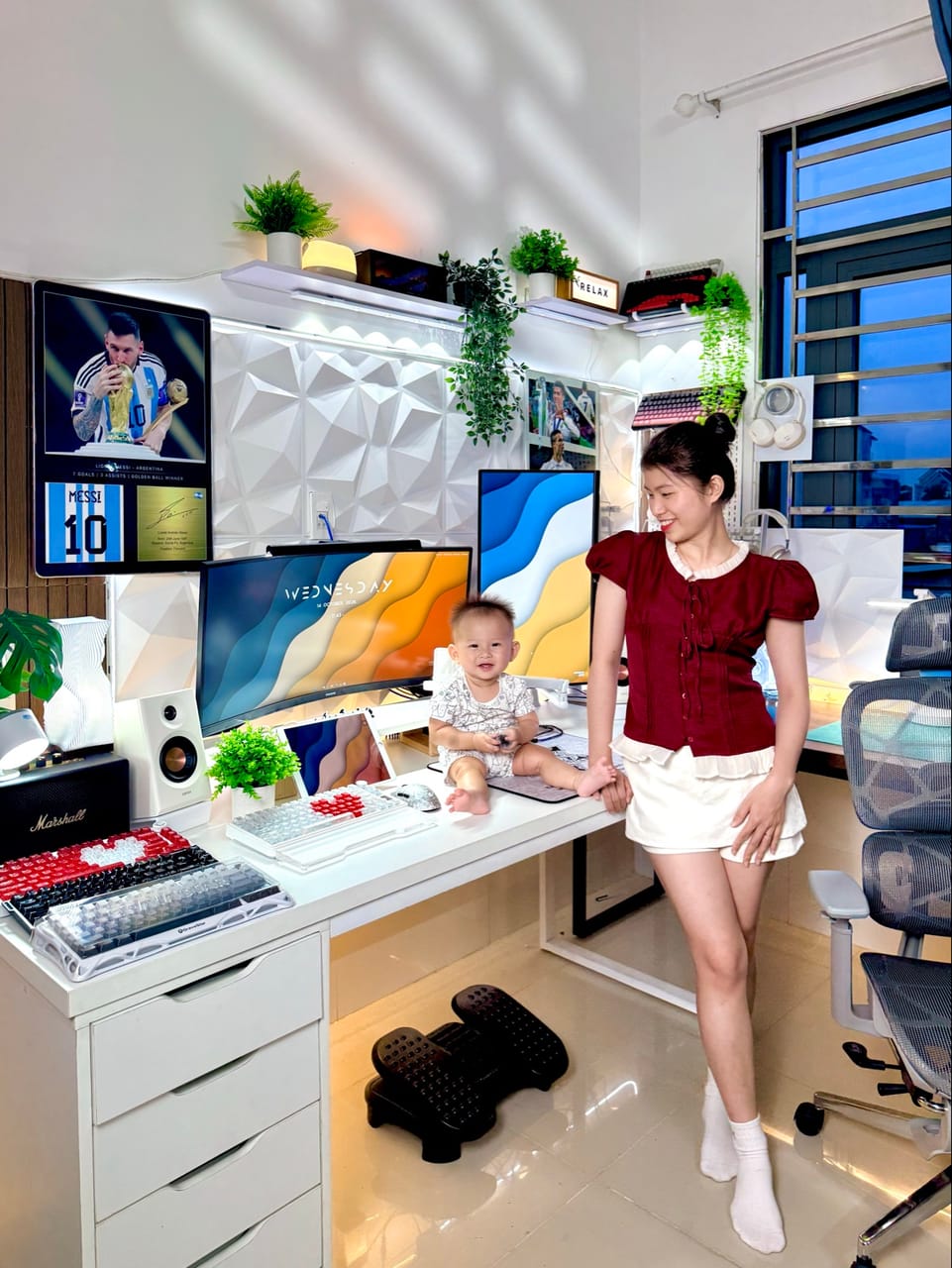 Setup góc máy của Tuấn Tiền Tỏi 🧄: Góc máy trắng chữ L, màn hình cong và màn dọc, nhiều bàn phím cơ, cây xanh, tường 3D và tranh Messi.