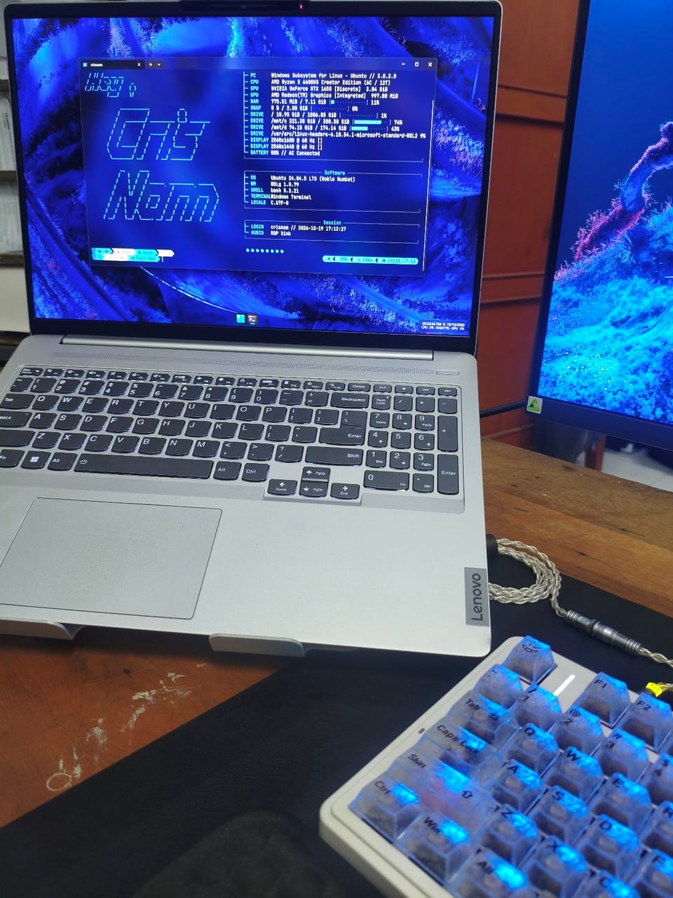 Góc máy của Cris Nam: Góc làm việc gọn gàng với laptop Lenovo màn hình kép và bàn phím cơ trong suốt.