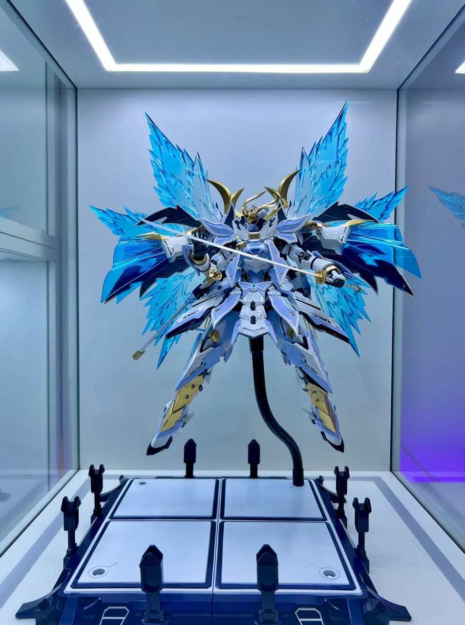 Góc máy của Túnn: Mô hình robot samurai trắng xanh với đôi cánh trong suốt được trưng bày trong tủ kính có đèn LED sáng đẹp mắt.