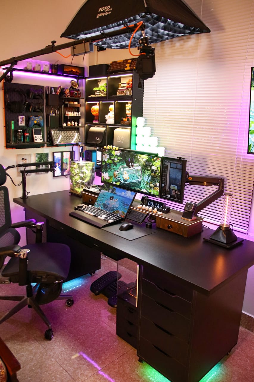 Góc máy của ĐÀO TIẾN HUY: Góc làm việc bàn đen ánh đèn RGB tím hồng, nhiều màn hình, softbox livestream, pegboard và kệ trưng bày đồ sưu tầm.