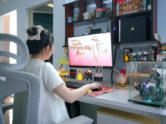 Góc máy của ThanhVinh: Góc máy tông trắng với kệ gỗ, nhiều mô hình xe, figure trong tủ kính, cây xanh và màn hình chúc mừng 20/10.