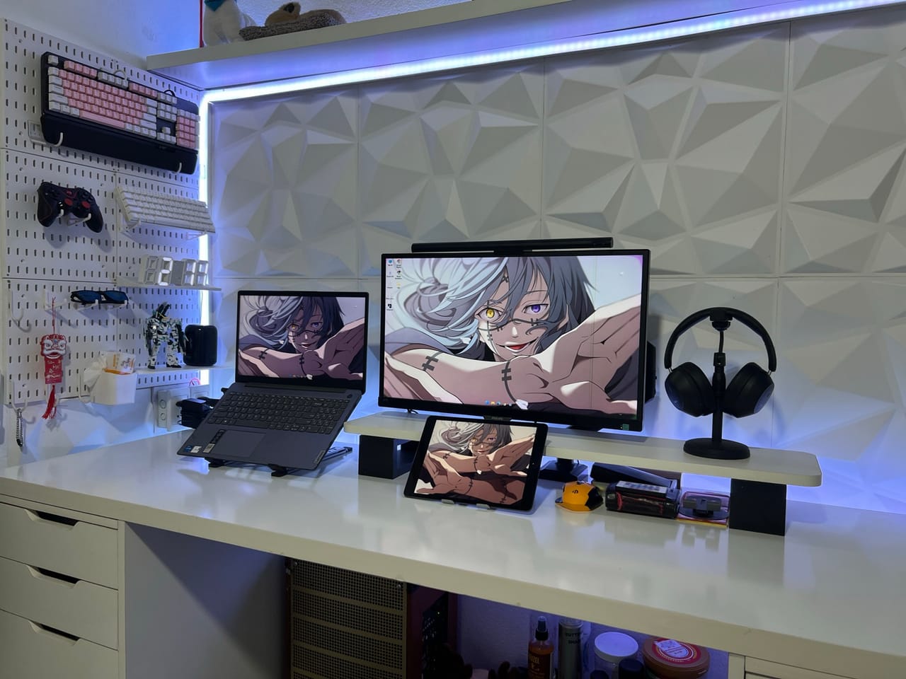 Góc máy của karrot: Góc bàn trắng gọn gàng với đèn LED tím xanh, tấm ốp tường 3D, bảng đục lỗ treo bàn phím, tay cầm và hình nền anime.