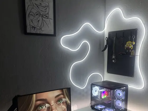 Góc máy của Lố: Góc setup tối giản tông trắng đen với PC case kính trong suốt, đèn neon uốn lượn trên tường, màn hình gắn arm và bảng pegboard treo đồ.