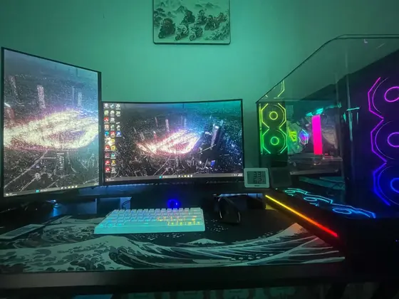 Góc máy của Q.hyy: Góc máy tối đèn RGB rực rỡ với hai màn hình hình nền ROG, case kính trong suốt, bàn phím trắng và lót chuột họa tiết sóng.