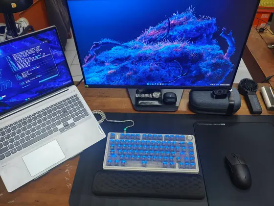 Góc máy của Cris Nam: Góc làm việc gọn gàng với laptop Lenovo, màn hình lớn và bàn phím cơ.