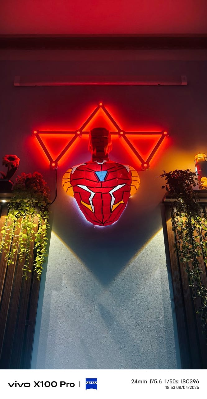 Góc máy của Hói: Góc tường trang trí tượng Iron Man phát sáng, đèn LED tam giác đỏ cùng cây xanh rủ hai bên.