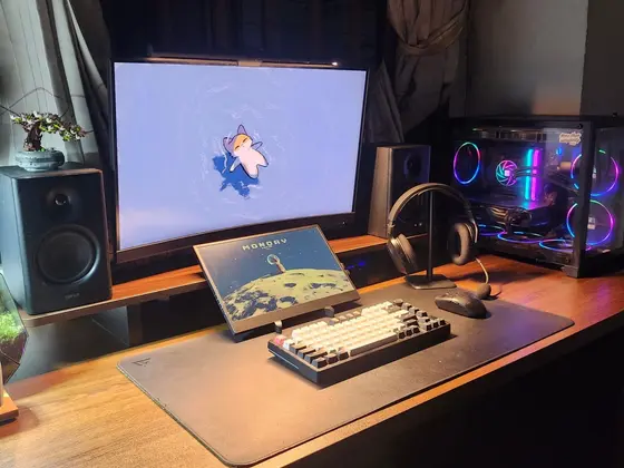 Góc máy của phtf: Góc máy ấm cúng trên bàn gỗ với màn hình cong, màn phụ, bàn phím cơ, loa Edifier và case RGB rực rỡ bên cạnh.
