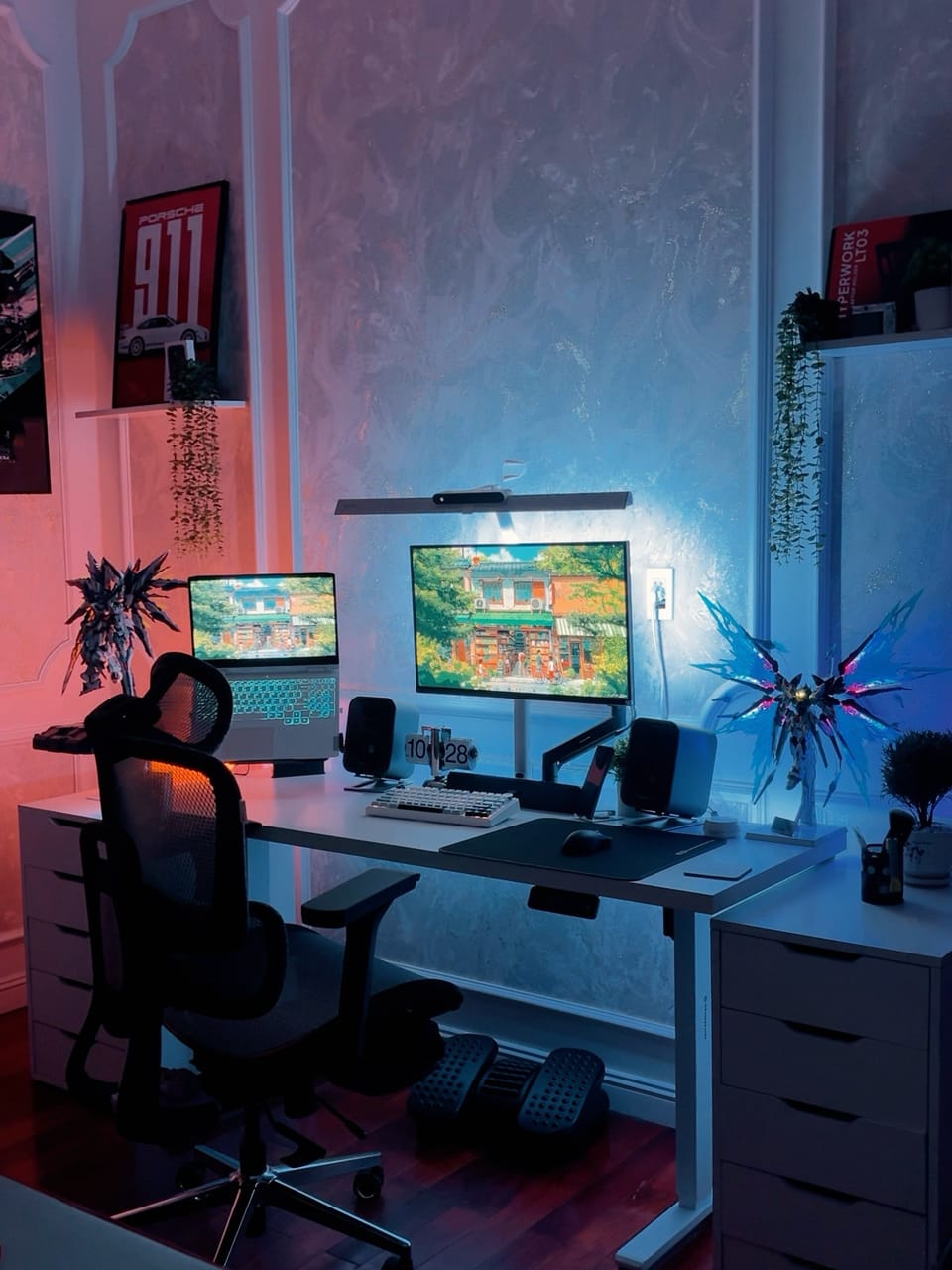 Góc máy của Wy: Góc máy tông trắng với đèn hắt hồng xanh, màn hình gắn arm, laptop, loa đôi và mô hình Gundam phát sáng.