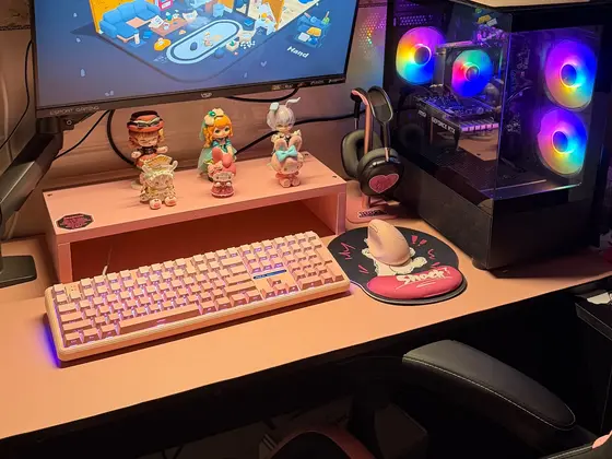 Góc máy của Liban: Góc máy tông hồng pastel dễ thương, bàn phím hồng, figure chibi trên kệ và case PC fan RGB rực rỡ.