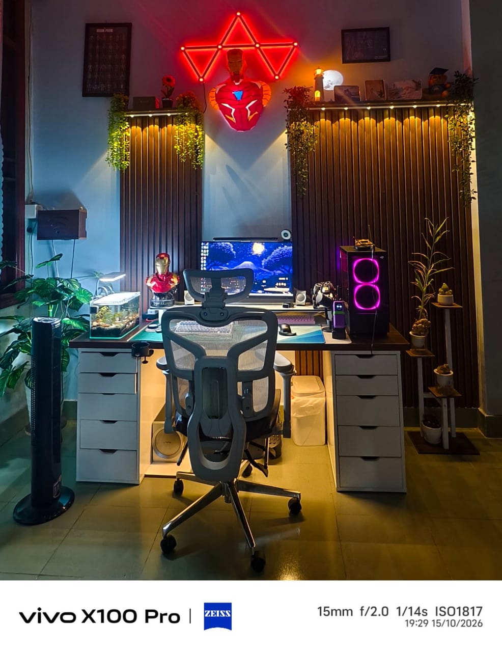 Setup góc máy của Hói: Góc máy chủ đề Iron Man với đèn tam giác đỏ, vách gỗ lam, cây xanh, bể thủy sinh và PC quạt hồng.