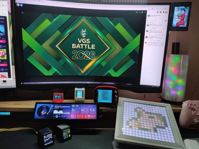 Góc máy tính trang trí nhiều màn hình phụ và đồ chơi công nghệ RGB bắt mắt.